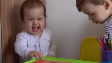 Çocukluk, üzüntü, histeri - otantik portre küçük üzgün bebek çocuk masanın yanında otururken ağlamak çok üzücü. Abim küçük kardeşime hakaret ediyor. Evde oyuncakları paylaşmıyor.