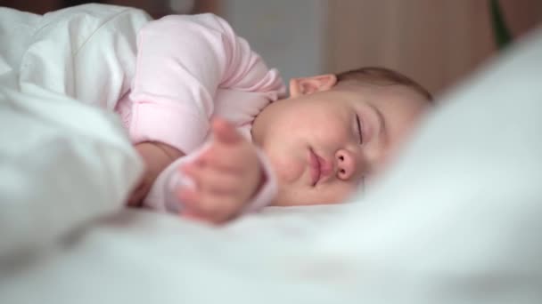 Auténtico retrato lindo bebé caucásico regordete niña o niño en sueño rosa con oso de peluche en la cama blanca. niño descansando a la hora del almuerzo. cuidado, Niñez durmiente, Infancia, paternidad, concepto de vida — Vídeo de stock