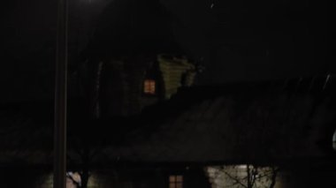 Gece parkında inanılmaz bir kar yağışı var. Arka planda fener var. Eski Rus ahşap kilise tapınağı tepsisinin yanında. Meteoroloji, Hava Durumu, Doğal Fenomen, Mutlu Noeller ve Yeni Yıl Konsepti