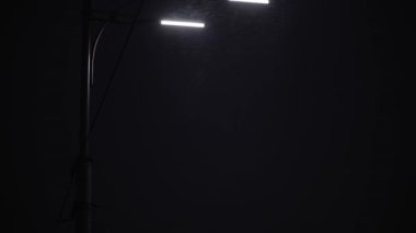 Gece yolundaki inanılmaz kar yağışı, kışın ilk saatlerinde fener arka planında. Akşam şehir manzarası. İnsanlar Noel arifesinde eve koşarlar. Hava Durumu, Doğal Fenomen, Mutlu Yıllar, Şehir Taşımacılığı Konsepti