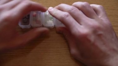 Erkeklerin el sıkışarak plastik organizatör kutusundan hap almalarına çok yakın. Hasta adam korku içinde tedavi arıyor. Geleneksel ve Alternatif Tıp ve Sağlık, covid-19 kavramı