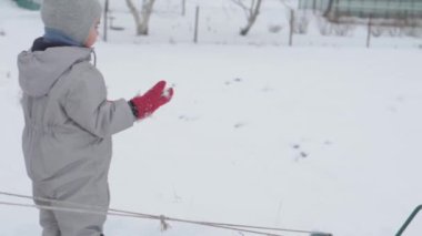 Tatil, oyun, aile kavramı - yavaş çekim otantik 3 mutlu anaokulu çocuğu kardeşler tepeden aşağı kayıp birbirlerine tırmanmada yardım ediyorlar. Soğuk mevsimde kar yağışı, kış parkında açık havada.