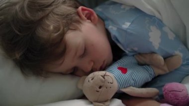 Üst düzey, otantik, beyaz, beyaz, anaokulu erkek kardeşleri, mavi pijamalı kız ve erkek çocukları beyaz yatakta oyuncak ayıyla uyurlar. çocuk istirahati, bakım, ilaç ve sağlık, çocukluk, yaşam konsepti