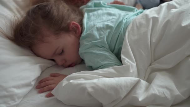 Autentický portrét roztomilé kavkazské malé předškolní sourozence chlapeček a dívka v modrém spánku s medvídkem na bílé posteli. dítě odpočívající v poledne. péče, medicína a zdraví, Dětství, životní koncept — Stock video