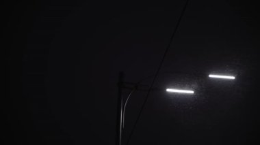 Gece yolundaki inanılmaz kar yağışı, kışın ilk saatlerinde fener arka planında. Akşam şehir manzarası. İnsanlar Noel arifesinde eve koşarlar. Hava Durumu, Doğal Fenomen, Mutlu Yıllar, Şehir Taşımacılığı Konsepti