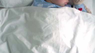 Üst düzey, otantik, beyaz, beyaz, anaokulu erkek kardeşleri, mavi pijamalı kız ve erkek çocukları beyaz yatakta oyuncak ayıyla uyurlar. çocuk istirahati, bakım, ilaç ve sağlık, çocukluk, yaşam konsepti