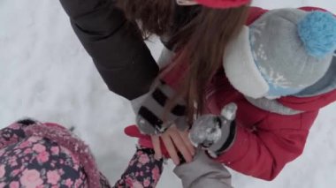 Tatil, oyun, aile konsepti - yavaş çekim özgün çocuklar el ele tutuşur, sıcak ilişkiler, destek, soğuk kış havasında takım oluşturma