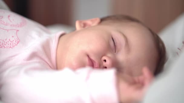 Autentický portrét roztomilý kavkazský malý baculatý holčička nebo chlapec v růžovém spánku s medvídkem na bílé posteli. dítě odpočívající v poledne. péče, Spící dítě, Dětství, Rodičovství, životní koncept — Stock video