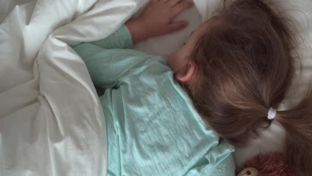 Auténtico retrato lindo caucásico pequeños hermanos preescolares bebé y niña en sueño azul con oso de peluche en la cama blanca. niño descansando a la hora del almuerzo. cuidado, medicina y salud, Infancia, concepto de vida — Vídeos de Stock