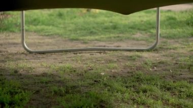 İlkbahar, spor, bayram, aile, çocukluk üç mutlu küçük çocuk anaokulu kardeş çocuklar trambolinde zıplayarak eğleniyorlar güneşli bir akşam günbatımında parkta.