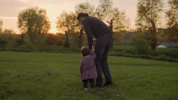 People in the park. happy family silhouette at sunset. dad and baby run holding hands have spend time. parents and fun children walking outdoors in open air. Fathers day, childhood, parenthood concept — Stock Video