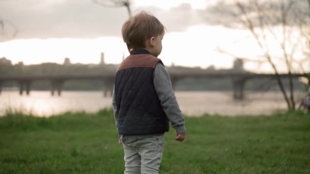 Little preschool toddler siblings children boy and girl catch soap bubbles in spring park at sunset. Happy kids friends have fun spend time. Leisure Time nature. Family, friendship, childhood concept — Stock Video