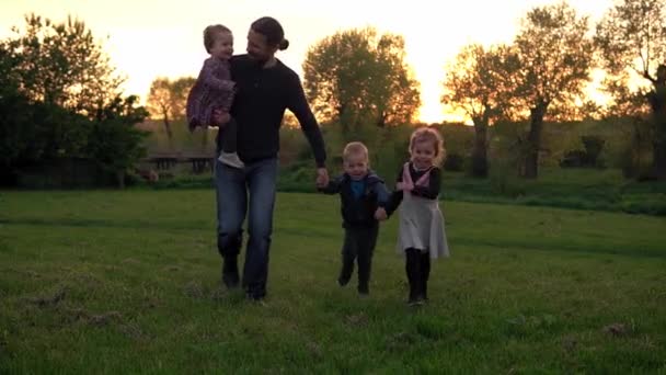 People in the park. happy family silhouette at sunset. dad and baby run holding hands have spend time. parents and fun children walking outdoors in open air. Fathers day, childhood, parenthood concept — Stock Video