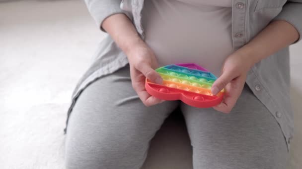 Auténtica mujer embarazada linda con pop se siente feliz en casa con el vientre. Joven madre jugar hoyuelo simple en el sofá blanco cerca de la ventana. Atención prenatal de maternidad, embarazo, maternidad, concepto de estilo de vida — Vídeos de Stock