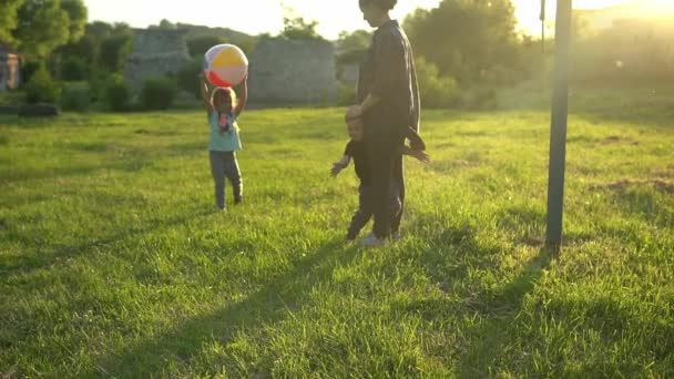 여름, 자연, 행복 한 가족, 행복 한 가정, 임신, 임신부, 아기 두 명을 둔 어머니는 해 가질 무렵 공원에서 큰 공을 가지고 놀고 있다. 행복하게 웃는 아이들은 재밌게 놀고, 웃고, 함께 시간을 보내죠 — 비디오