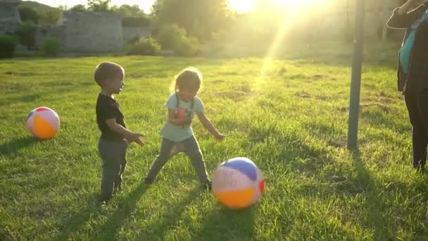 Lato, natura, szczęśliwa rodzina, ciąża, Dzień Matki - ciężarna mama z dwójką dzieci bawiących się w gry z dużą piłką w parku o zachodzie słońca. Szczęśliwy uśmiech Dzieci baw się dobrze, śmiej się spędzać czas razem — Wideo stockowe