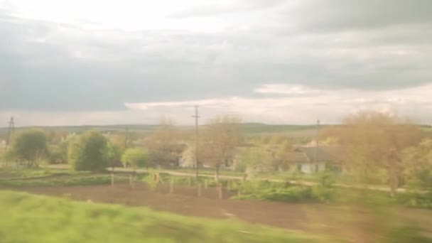 View from window of high-speed train on landscape of beautiful nature wild field and forest on evening cloudy dusk sky sunset in summer background. Transport, travel, railway, communication concept — Stock Video