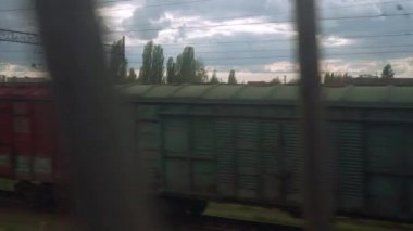 Yüksek hızlı tren penceresinden, paslı vagonların ve yüksek tuğlalı bacaların manzarasından yaz arkaplanındaki bulutlu güzel gökyüzünün manzarasına. Ulaşım, seyahat, demiryolu, yol, zina kavramı