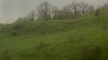 Yüksek hızlı trenin penceresinden manzaralı güzel doğa yolu manzaralı araba ve ormanlı yaz arkaplanındaki alacakaranlık gökyüzü günbatımında. Ulaşım, seyahat, demiryolu, iletişim konsepti