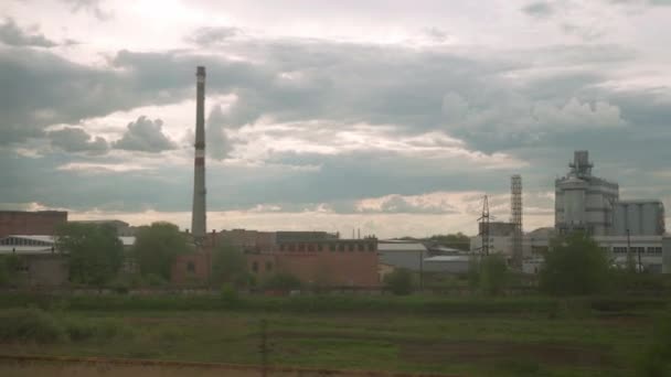 Vista desde la ventana del tren de alta velocidad en el paisaje de hermoso campo de la naturaleza Zona Industrial en la noche nublado atardecer cielo puesta de sol en el fondo de verano. Transporte, viajes, ferrocarril, concepto de comunicación — Vídeo de stock