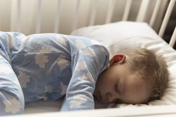 Bovenaanzicht Schattig klein jongetje van 2-3 jaar dat lekker in het wit slaapt tijdens de lunch in een blauwe pyjama met kussen thuis. Jeugd, vrije tijd, comfort, geneeskunde, gezondheidsconcept — Stockfoto