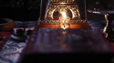Din, bayramlar, konsept - Hıristiyan Ortodoks tapınağındaki sunak tahtına düşen dumanlı odadaki pencereden gelen ışık ışınları yanında şamdan yakan şamdanla avize altında.