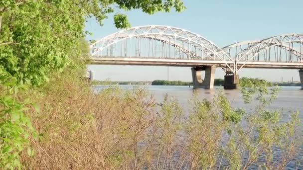 Ver la pesca en movimiento velero a motor en el río Dnipro al atardecer. paisaje de puente industrial sobre lago en ciudad. camión y coche pasa sobre el estanque en el soleado día de verano el transporte de agua, viajes — Vídeo de stock