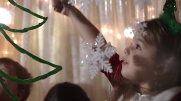 Authentique maman mignonne et deux petits enfants d'âge préscolaire mineurs frères et sœurs fille et garçon 2-4 ans dessinent arbre de Noël sur la fenêtre. jeune femme avec enfants colle des flocons de neige. Noël, Nouvel An, concept d'hiver. — Video