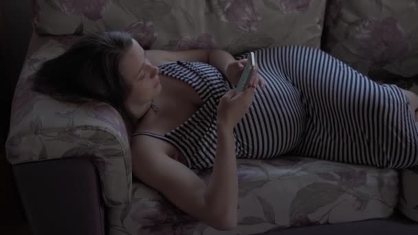 Счастливая беременная женщина с планшетом иметь видеозвонок с помощью смартфона общается с мужем через чат онлайн консультации с врачом поговорить с друзьями на мобильном телефоне. беременность, технологии, медицина — стоковое видео