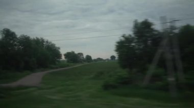 Yüksek hızlı trenin penceresinden manzarası güzel doğa manzarası vahşi arazi ve orman akşam bulutlu gökyüzü günbatımı yaz arkaplanında. Ulaşım, seyahat, demiryolu, iletişim konsepti