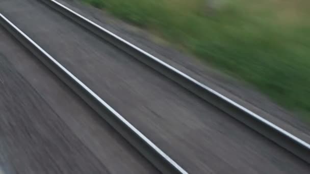 Θέα από το παράθυρο υψηλής ταχύτητας τρένο για το τοπίο της όμορφης φύσης άγριο πεδίο και σιδηροτροχιές δασικές σιδηροδρομικές γραμμές το βράδυ ηλιοβασίλεμα στο φόντο του καλοκαιριού. Μεταφορές, ταξίδια, σιδηρόδρομοι, επικοινωνία — Αρχείο Βίντεο