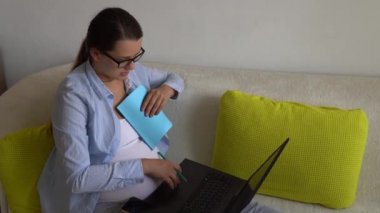 Laptop ve Noutbook 'u olan başarılı ve çalışkan hamile iş kadını. Hamilelik Çalışması Evrakları Uzaktan Akıllı Telefon İnternet ve Çevrimiçi Teknoloji 'yi Evinde Kullanıyor. Doğum izni.