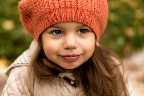 Close Up Portret van kleine schattige kleuter meisje in oranje baret op gele gevallen bladeren mooi glimlachend op zoek naar camera in koud weer in het najaar Park. Jeugd, Familie, Moederschap, Herfst Concept — Stockfoto