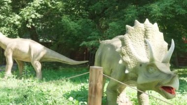 2021.08.12 - Kiev, Ukrayna: Motorize Dinazor Avcısı Triceratops ve Eğlence Ormanı Parkı 'nda Brachiosaurus Mockup. Dinopark 'taki Jurassic Tarih Öncesi Dönemin Hareket Eden Modelleri Sergisi