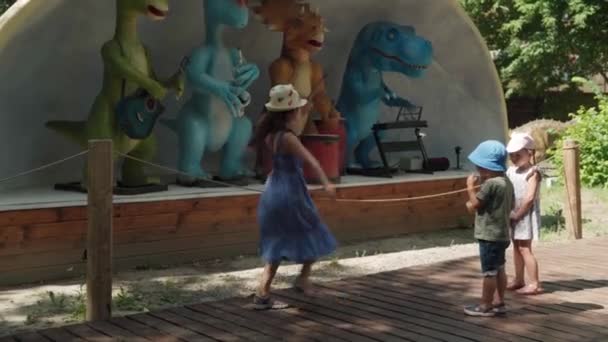 2021.08.12 - Kiev, Oekraïne: Kinderdans Veel plezier in de buurt van het podium met bewegend model Dinosaurussen Musici Mockup. Diverse gemotoriseerde dieren met muziekinstrumenten Depict Rosk Group in Dinopark — Stockvideo