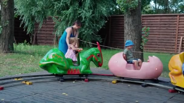 2021.08.12 - Kiev, Ukraine: Little Preschool Children Ride in Circle on Kids Train with Carriages in Shape of Dinosaurs or Animals Have Fun Spend Time. Motorized Dinosaur Predator Mockup in Dinopark — Stock Video