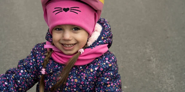 Sport, vrije tijd, jeugdconcepten - Close-up kleine schattige glimlach schoolmeisje kleuterschool minderjarige meisje dragen beschermende veilige fiets helm rit naar school op de fiets in het park buiten in de herfst koud weer — Stockfoto