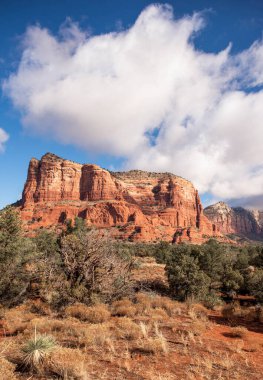 Sedona Arizona 'daki kırmızı kayalık dağ manzarası mavi gökyüzü ve bulutlarla