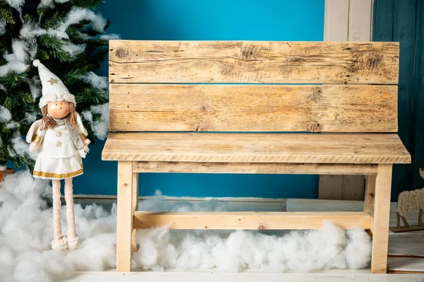 装饰圣诞工作室 带有蓝色门 木制长椅和滑雪板 假云彩和雪的房子 免版税图库图片