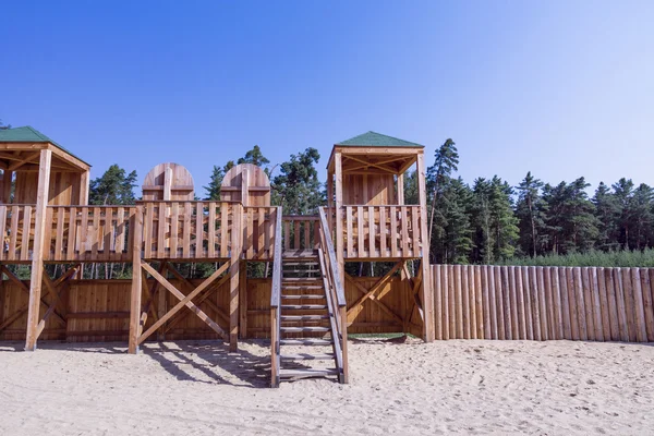 Wooden building with a wall in the woods — Stock Photo, Image