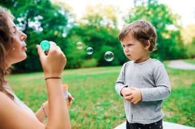 Genç hamile anne oğlu yaz park ve darbe kabarcıkları ile dinlenme