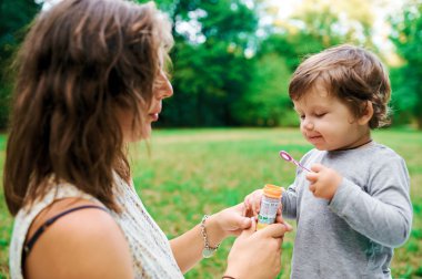 Genç hamile anne oğlu yaz park ve darbe kabarcıkları ile dinlenme