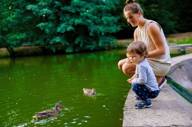 Genç hamile anne ile küçük oğlu yaz Park yürüme