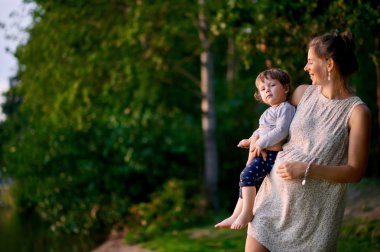 Hamile anne ile küçük oğlu yaz Parkı yürüme 