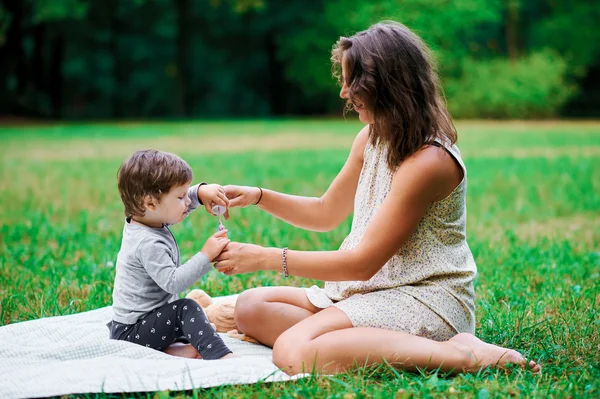 妊娠中の若い母親は、夏の公園と bl で彼女の息子と休憩 — ストック写真
