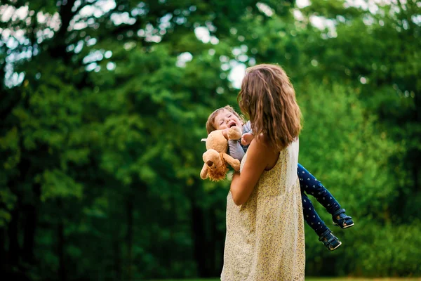 夏の公園で彼女の小さな息子と歩いて若い妊娠中の母親 — ストック写真