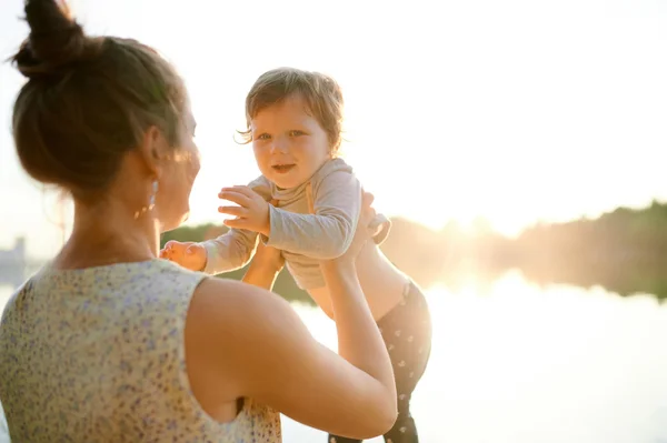 夏の公園で彼女の小さな息子と歩いて若い妊娠中の母親 — ストック写真