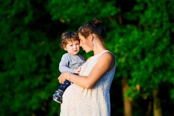 Young and happy pregnant mother walking with her little son in s — Stock Photo, Image