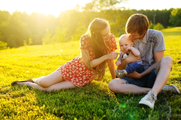 Happy and young  family resting on the beautiful lawn — Stock Photo, Image