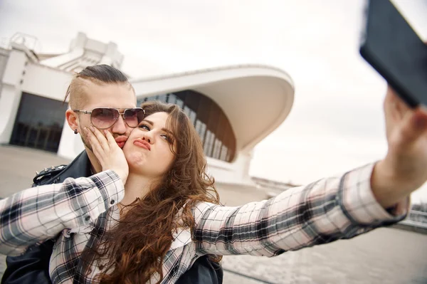 Mladí a šťastný pár baví ve městě je fotografoval na smartphone — Stock fotografie